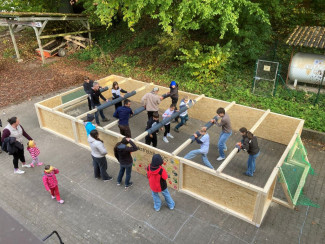 Jugendliche und Kinder spielen Menschenkicker